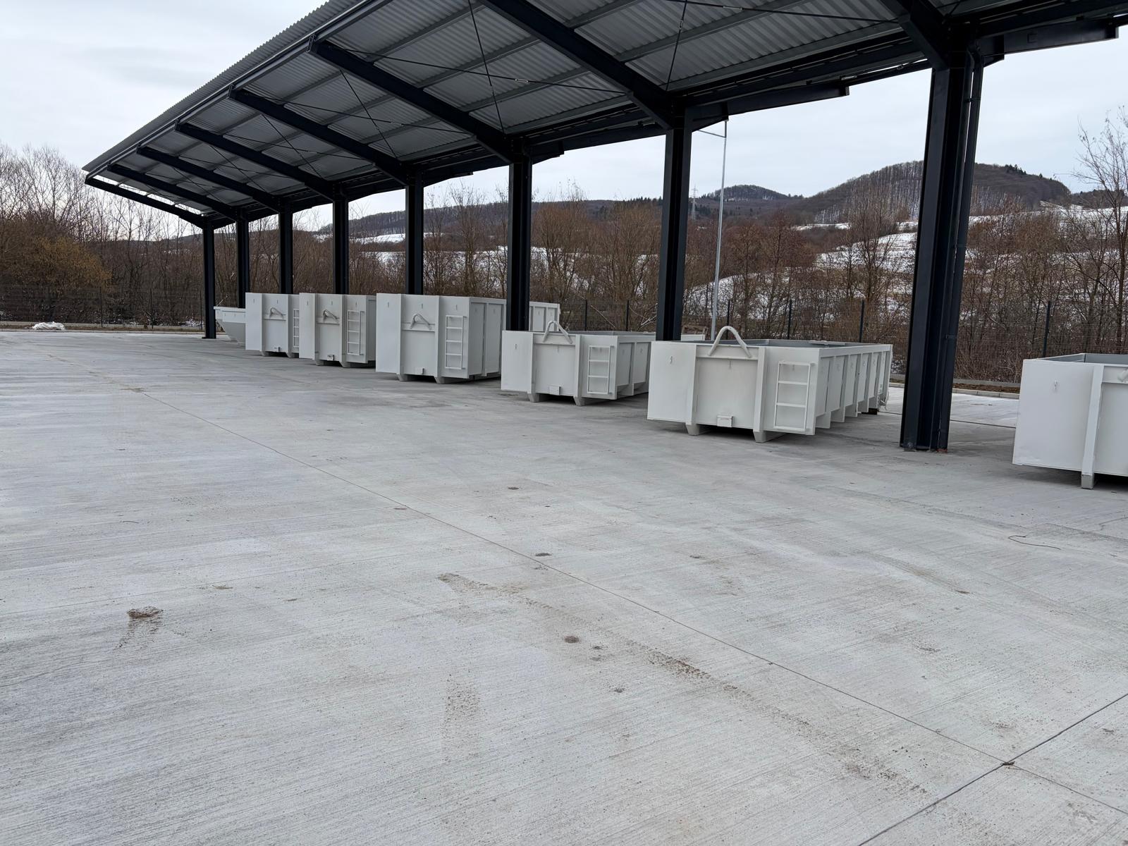 Rândurile de containere noi sub copertina metalică, gata pentru utilizare