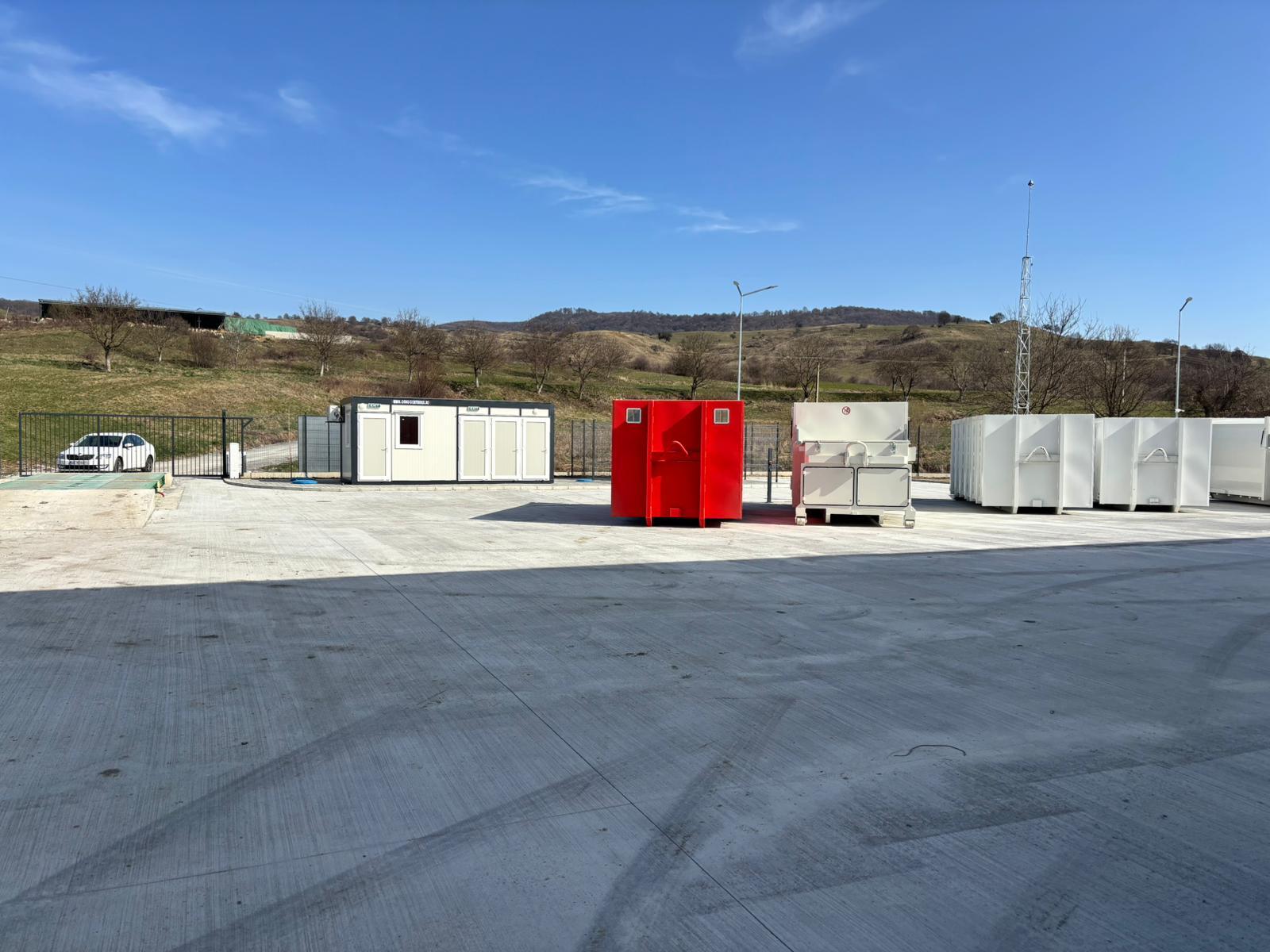 Poarta de acces deschisă, cu o mașină vizibilă lângă centru